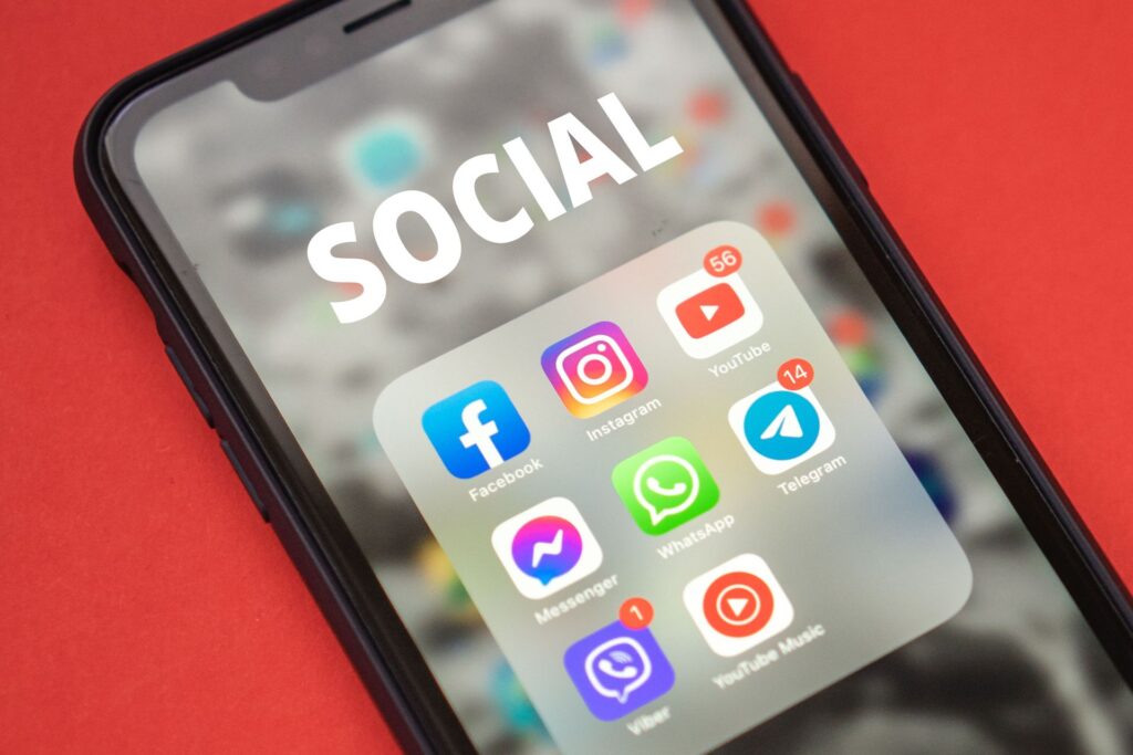 Smartphone showing a folder of social media apps including Facebook, Instagram and YouTube